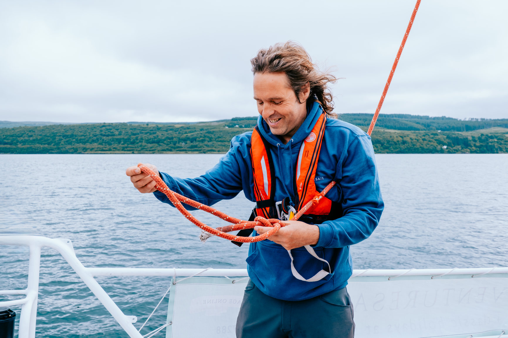 Man tying ropes on a boat at sea