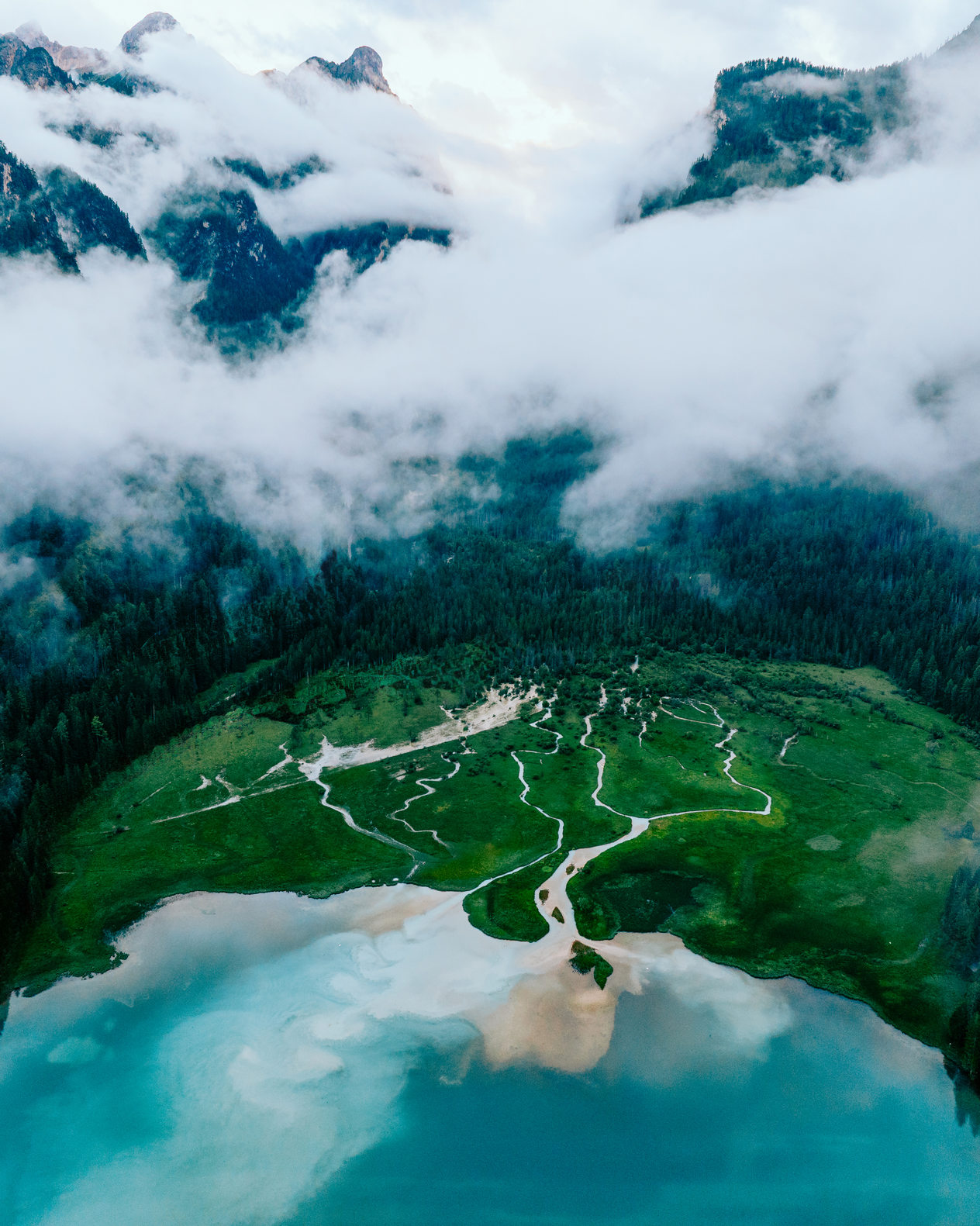 Moody Dobbiaco lake surrounded in clouds
